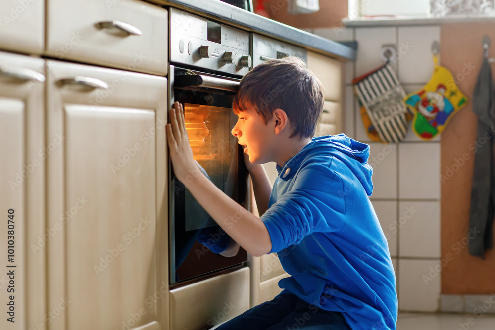 Cute blond boy baking muffins or pie in domestic kitchen. Happy child having fun with helping, sitting near ofen and waiting for cupcakes. Kid baking for Thanksgiving or Christmas holiday. Cute blond boy baking muffins or pie in domestic kitchen. Happy child having fun with helping, sitting near ofen and waiting for cupcakes. Kid baking for Thanksgiving or Christmas holiday.
