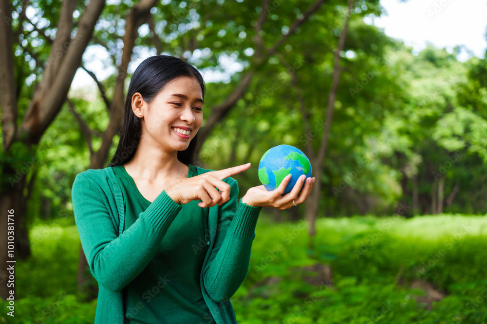 An Asian woman holds a globe in a green forest,symbolizing the importance of preserving nature.emphasizes balance between humans, natural resources,sustainable environmental development protect An Asian woman holds a globe in a green forest,symbolizing the importance of preserving nature.emphasizes balance between humans, natural resources,sustainable environmental development protect