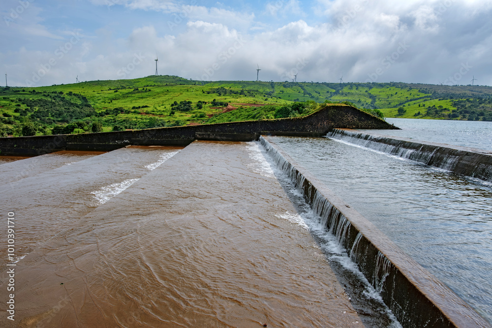 Water flows down the Jagmin step dam near Satara India at the end of the monsoons. Monsoon is the annual rainy season in India from June to September.