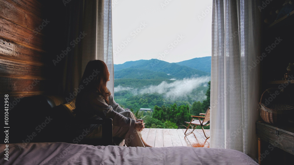 Φωτογραφία Portrait image of a woman sitting in bedroom and looking at a beautiful mountain