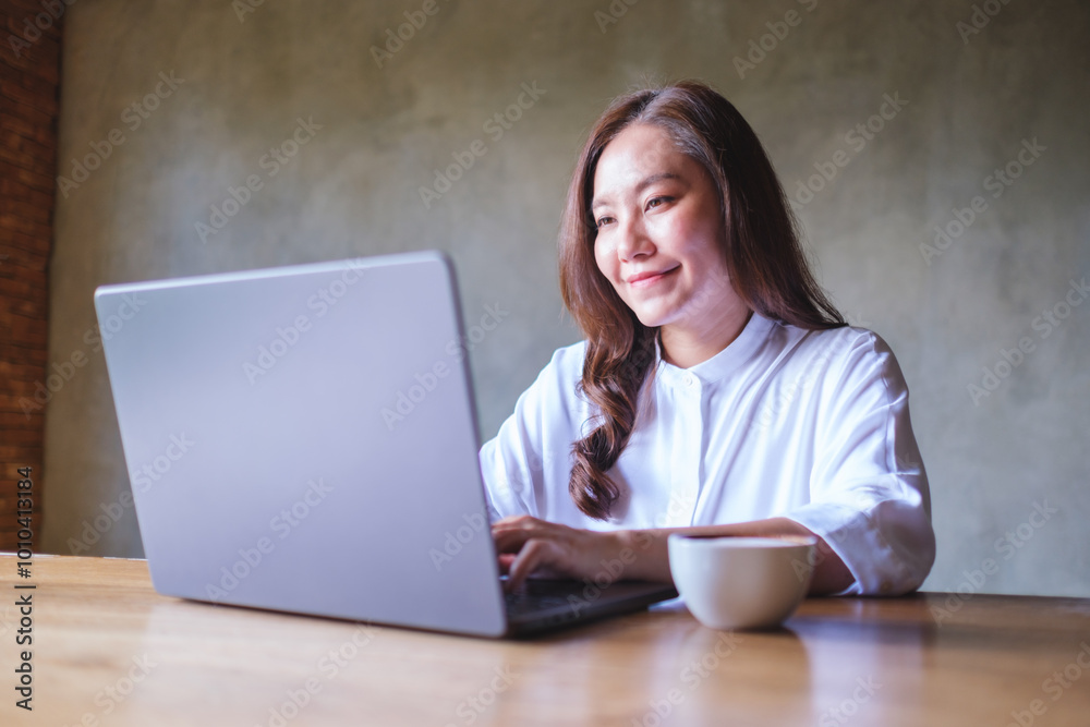 Portrait image of a young woman working on laptop computer Portrait image of a young woman working on laptop computer