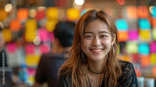 A woman with long brown hair is smiling at the camera