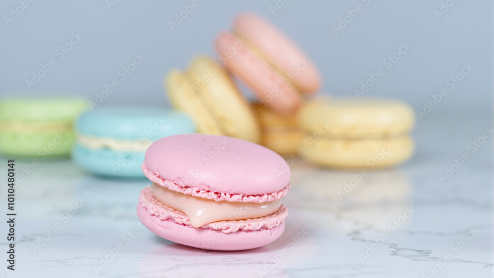 Fototapeta premium pink macaroon with a variety of other colors on white granite