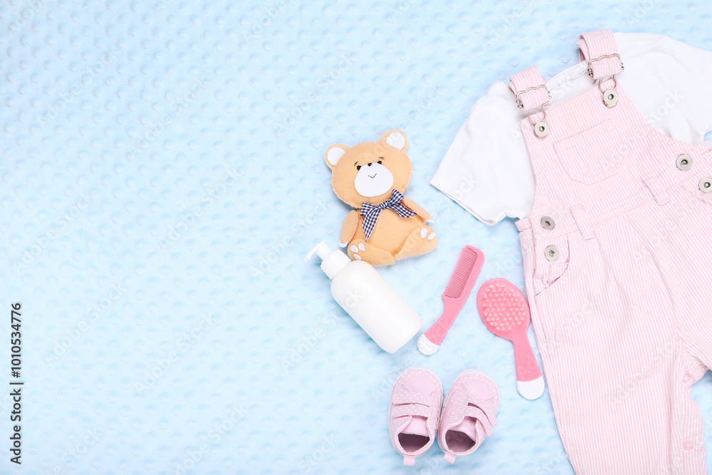 Φωτογραφία Clothes with toys and baby supplies on blue background