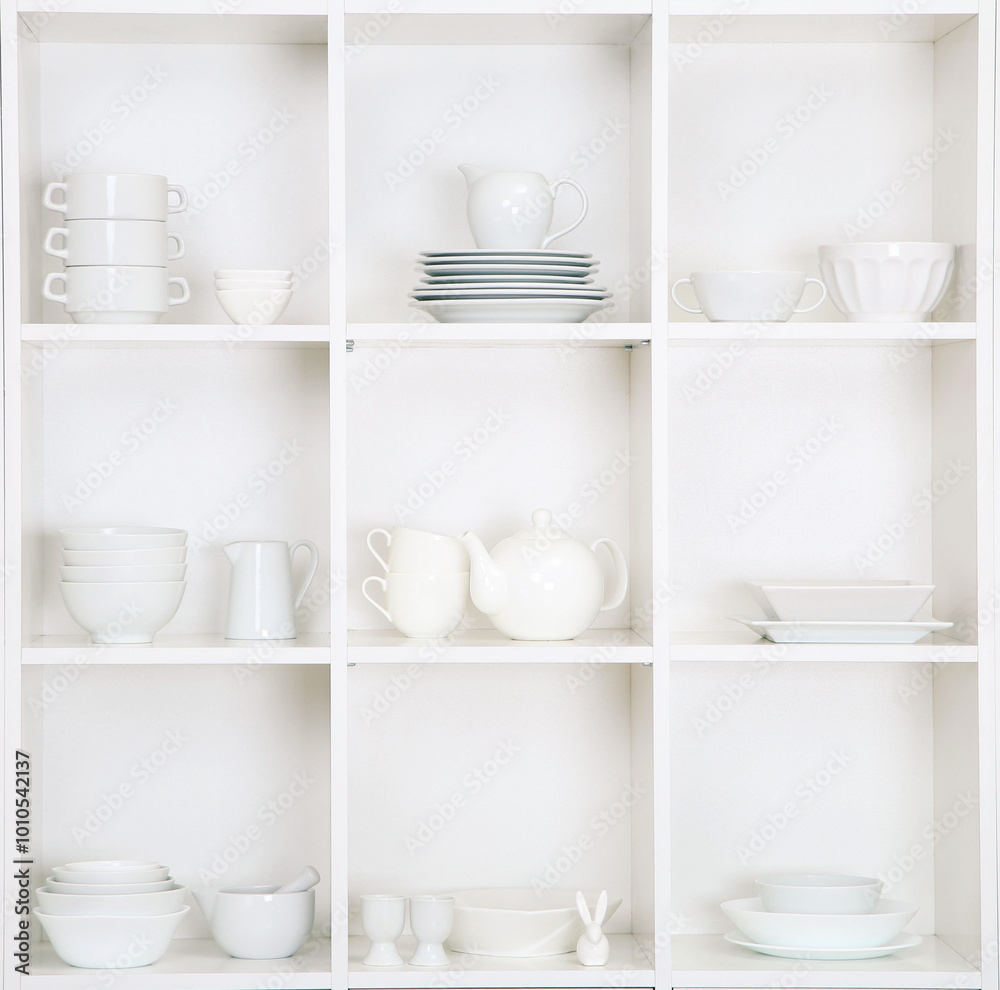 Shelves in wooden rack with white kitchen dishes close up