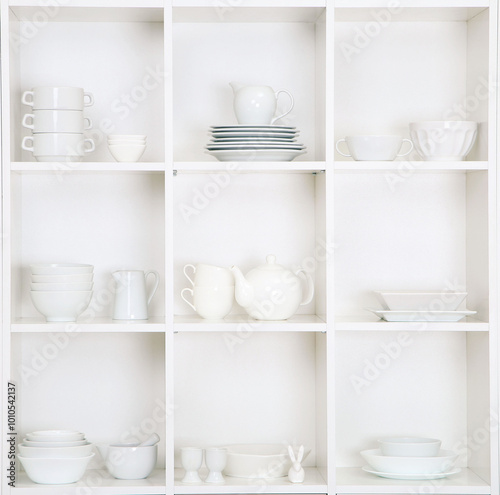 Obraz na płótnie Shelves in wooden rack with white kitchen dishes close up w salonie