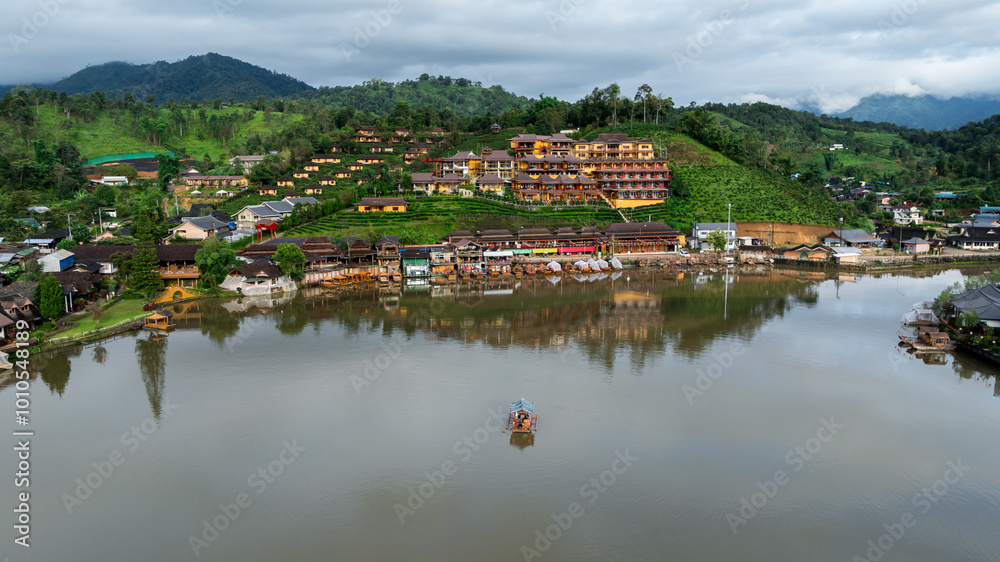 Obraz premium aerial view of hills and Chinese buildings in Ban Rak Thai Village and small raft tourist at Ban Rak Thai Resort, Mae Hong Son, Thailand