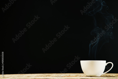 Cup of drink with steam on black background photo