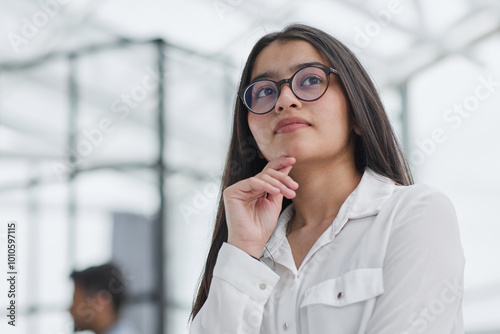 a girl stands in a modern office and looks at the camera