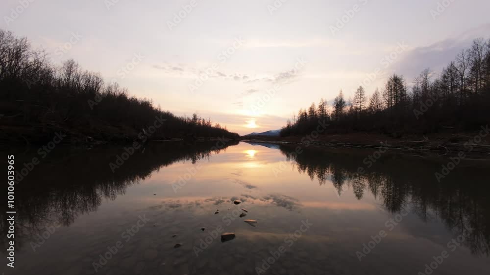 A breathtaking view unfolds as the sun dips below the horizon, casting golden reflections on a calm river A breathtaking view unfolds as the sun dips below the horizon, casting golden reflections on a calm river