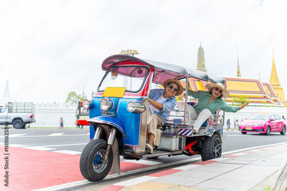 Fototapeta premium Group of Asian senior woman tourist enjoy outdoor lifestyle travel Bangkok city, Thailand on summer holiday vacation. Elderly women travel Wat Phra Kaew Temple by three wheeled vehicles Tuk Tuk taxi.
