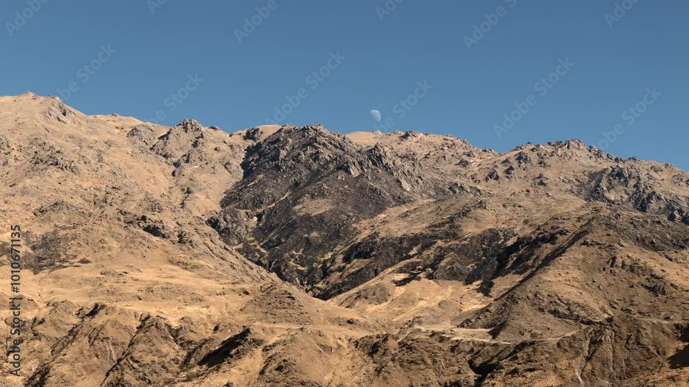 Aerial view of arid mountain with the moon in the sky. Andes mountain range. Tafí del Valle, Tucumán, Argentina. Aerial view of arid mountain with the moon in the sky. Andes mountain range. Tafí del Valle, Tucumán, Argentina.