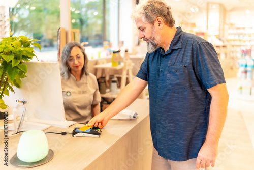 Man paying with credit card on a pharmacy store