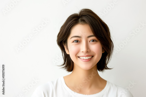 Portrait of a young Asian woman in a white shirt on a white background