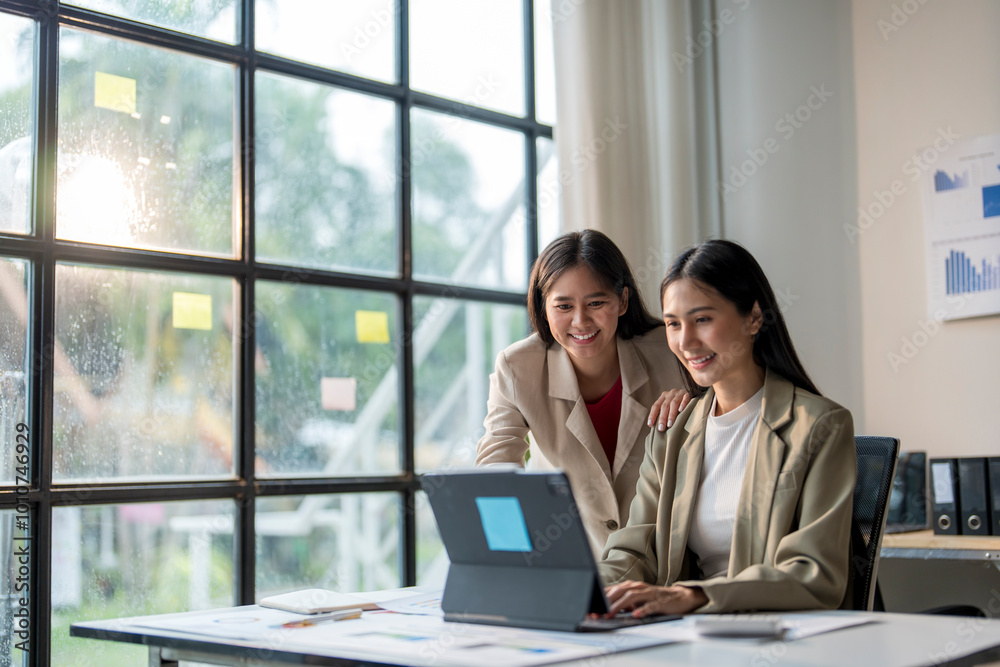 Two young businesswomen working on a project using a laptop in their office Two young businesswomen working on a project using a laptop in their office
