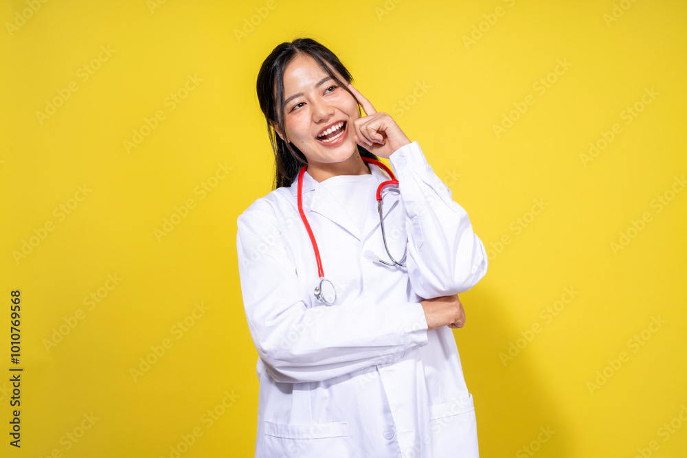 A woman in a white lab coat is smiling and pointing to her forehead A woman in a white lab coat is smiling and pointing to her forehead