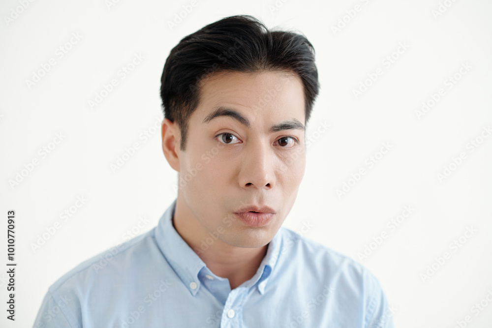 Portrait of surprised young man looking at camera on white background Portrait of surprised young man looking at camera on white background
