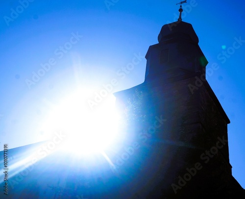 Kirche mit weißem strahlendem Sonnenlicht vor blauem Himmel bei Sonne am Morgen im Spätsommer photo