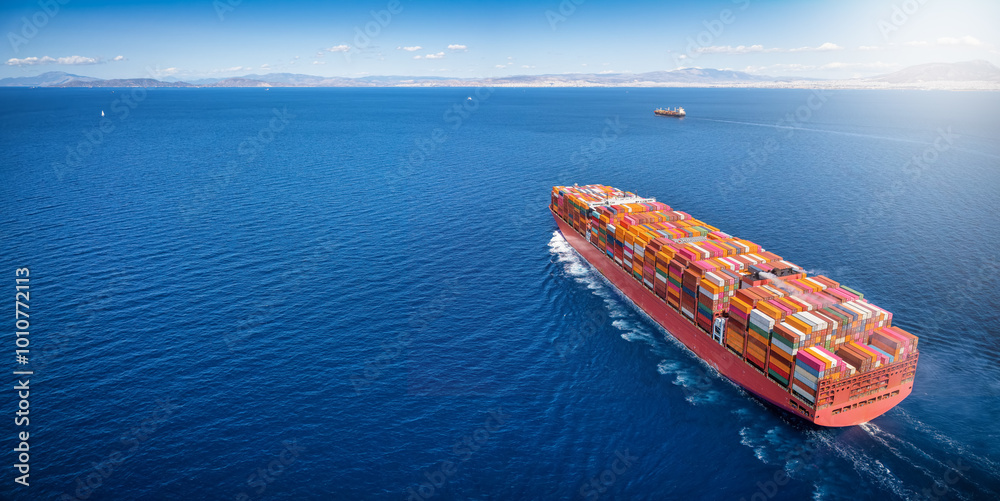 Aerial view of a super cargo container carrier ship traveling over the ocean as a concept banner for transport and industry
