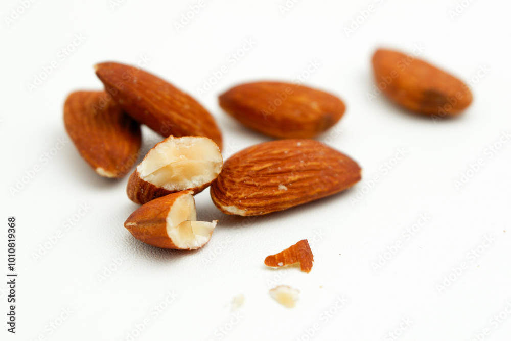 Crack broken cut in half almond nuts on white surface Crack broken cut in half almond nuts on white surface