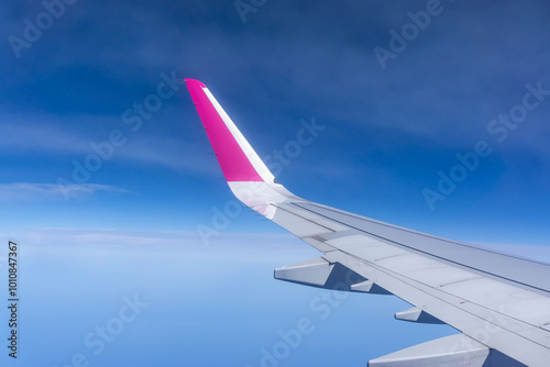 Airplane wing flying over the clouds one morning