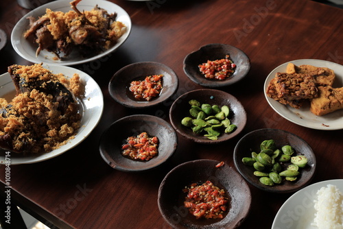 Lalapan or fresh raw vegetables basket with Pete (petai), chili sauce or sambal photo