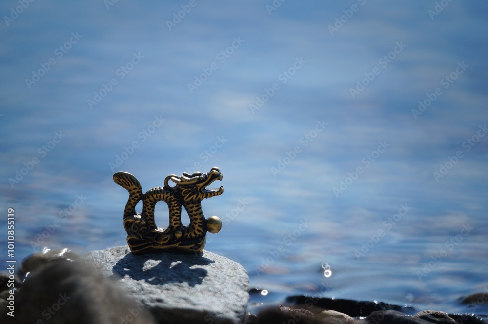 Fototapeta premium A metal dragon figurine on the riverbank.