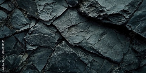 A close up of a rock wall with a black background. The wall is made of large rocks and has a rough texture