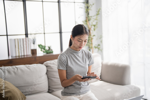 Asian Woman Pressing calculator for. financial planner remotely Personal finance at home.