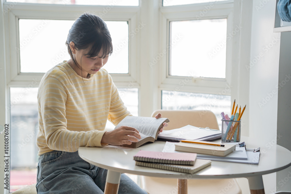 Student asian woman reading book in dorm room college student do homework in university dormitory Student asian woman reading book in dorm room college student do homework in university dormitory