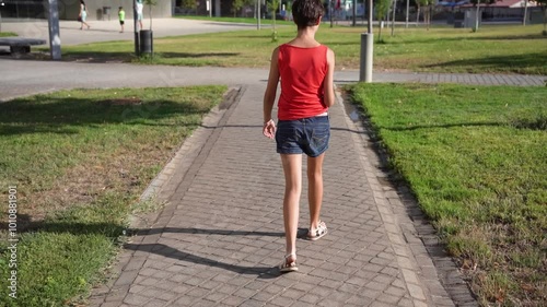 A happy child is walking on a beautiful pathway located in a lovely park setting photo