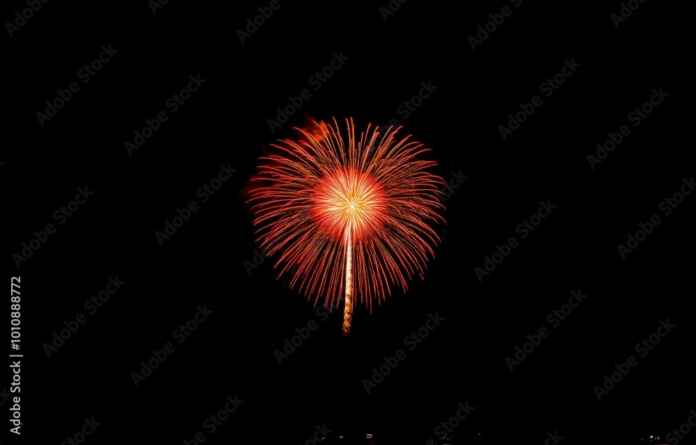 A single firework bursts in the night sky with vibrant red and orange hues. A single firework bursts in the night sky with vibrant red and orange hues.