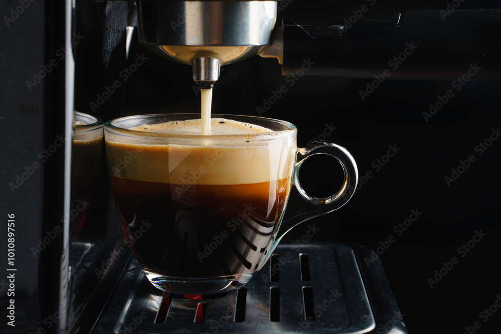 Fototapeta premium Pouring coffee into the coffee cup close up.Automatic coffee machine.