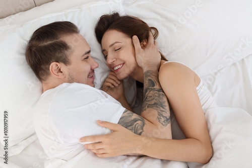 Happy couple lying on bed at home