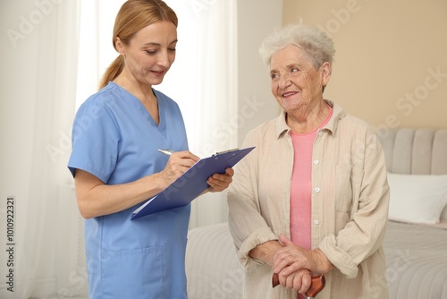 Healthcare worker with clipboard consulting senior woman indoors