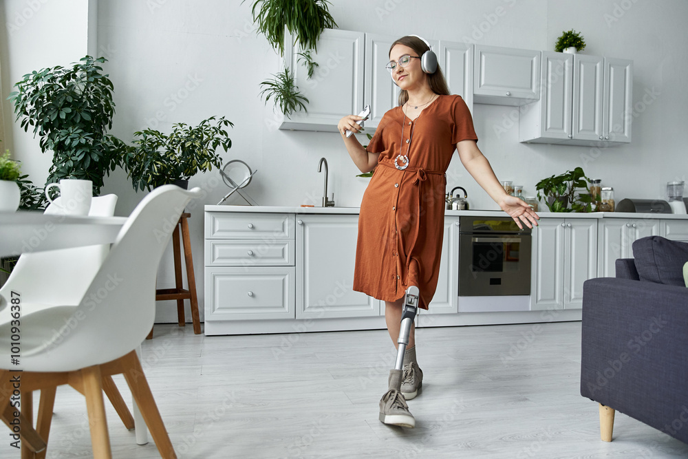 A woman with a prosthetic leg dances in a kitchen, wearing a dress and headphones. A woman with a prosthetic leg dances in a kitchen, wearing a dress and headphones.