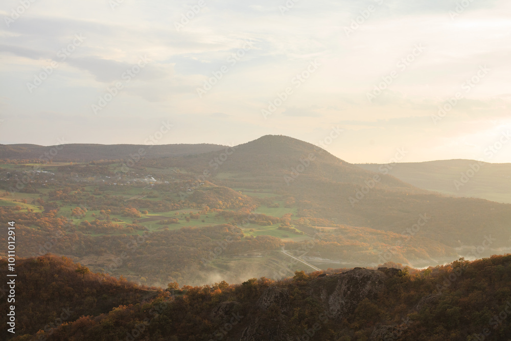 a panoramic view of autumn landscape with mountain hills surrounded by trees with yellow and red foliage at birtvisi canyon in georgia at a sunset light a panoramic view of autumn landscape with mountain hills surrounded by trees with yellow and red foliage at birtvisi canyon in georgia at a sunset light