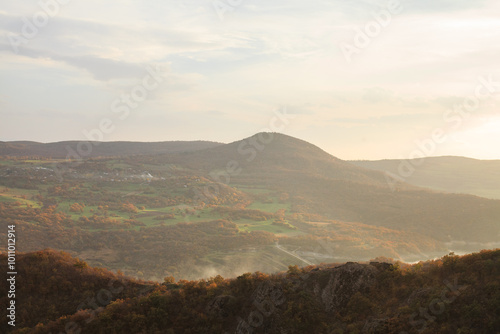 a panoramic view of autumn landscape with mountain hills surrounded by trees with yellow and red foliage at birtvisi canyon in georgia at a sunset light