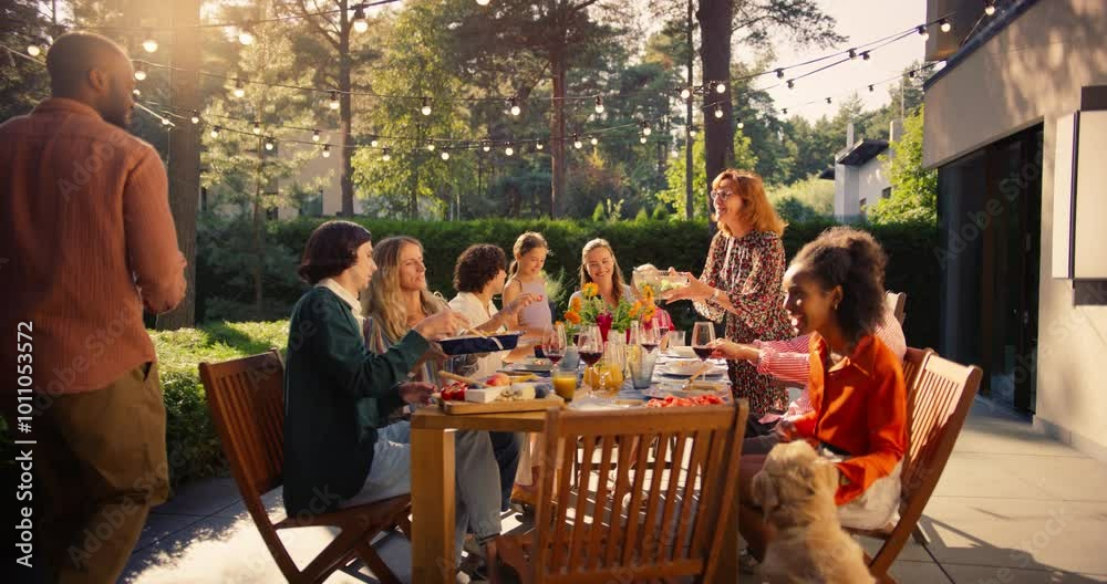 Diverse Men and Women Enjoy a Lively Garden Party at Sunset, Sharing Food and Drinks Outdoors. Man Grilling Meat Nearby while a Golden Retriever Roams Around, Adding to the Festive Atmosphere
