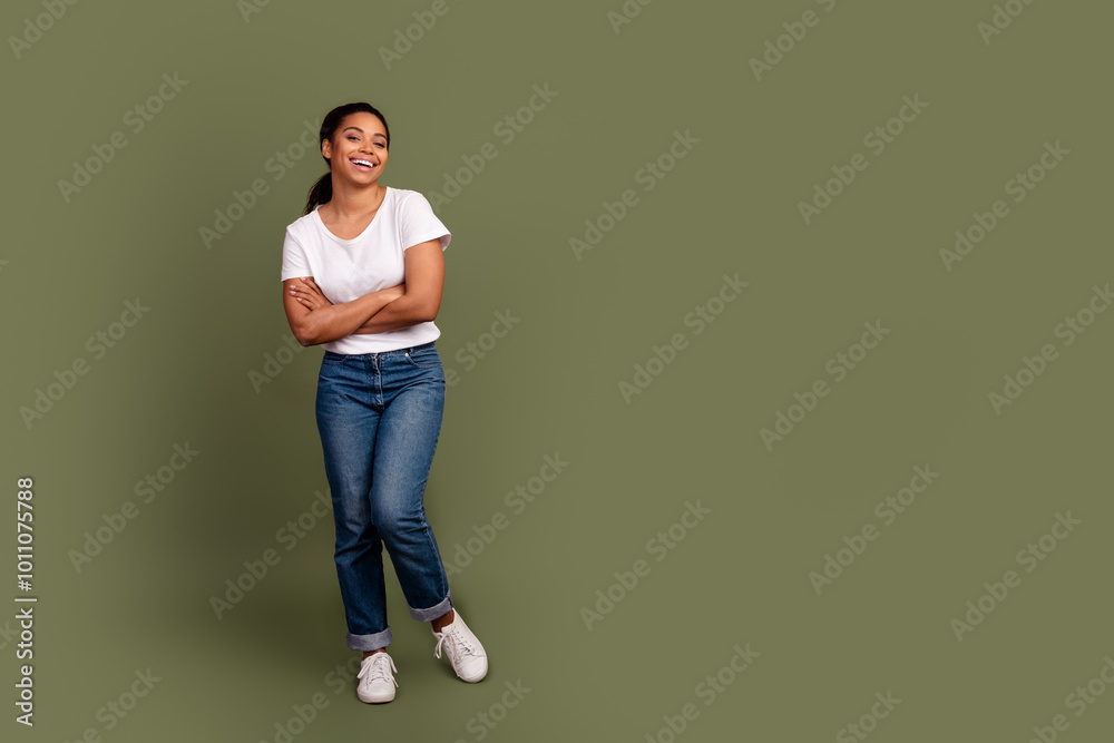Full size photo of nice young woman folded arms empty space wear white t-shirt isolated on khaki color background Full size photo of nice young woman folded arms empty space wear white t-shirt isolated on khaki color background