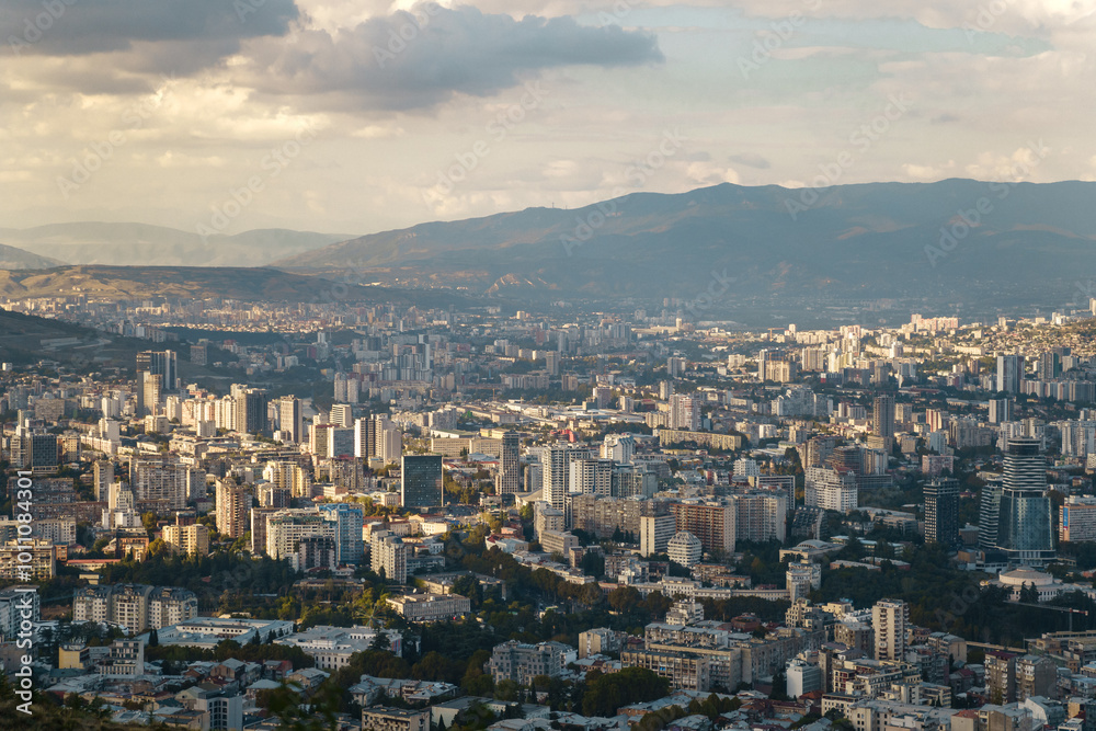 Fototapeta premium Expansive urban skyline overlooking a bustling city nestled between mountains at sunset