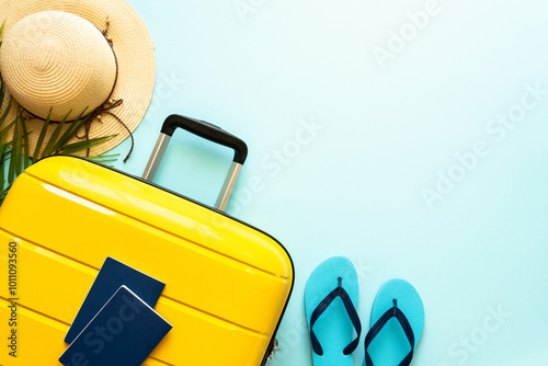 Obraz na płótnie Suitcase, hat and flip flops on blue background. Happy Holidays, travel concept. Flat lay with space for text. w salonie