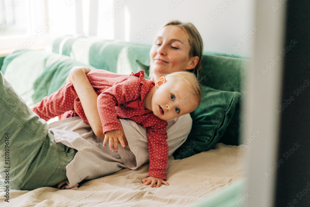 A young mother plays and takes care of her toddler daughter at home. A young mother plays and takes care of her toddler daughter at home.
