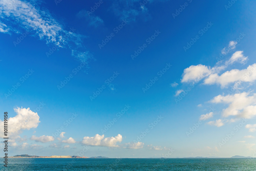 Fototapeta premium Tranquil Seascape with Vibrant Blue Sky and Soft Clouds