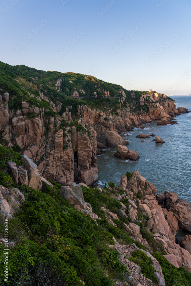 Serene Coastal Landscape with Rugged Cliffs and Tranquil Sea Serene Coastal Landscape with Rugged Cliffs and Tranquil Sea