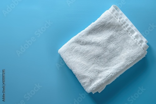 Neatly folded white towel on a blue background