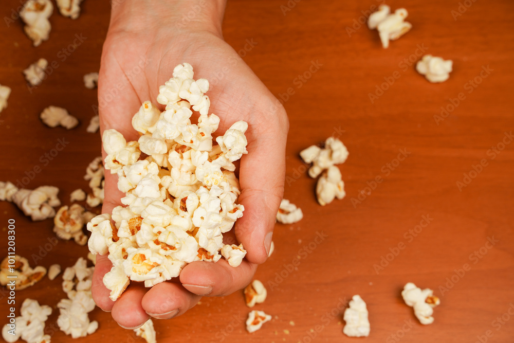 Delicious snack to eat in the cinema. Salted popcorn. Popcorn. Fast food. Junk food. Snack for cinema. Flavored spicy popcorn in man's hands.