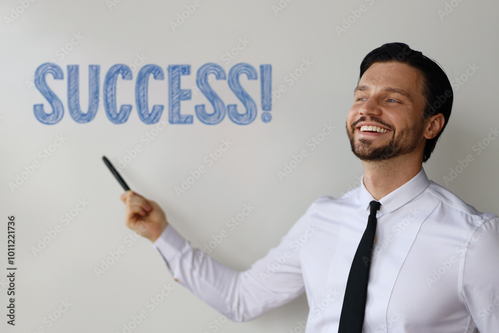 A man is smiling and pointing at a white board with the word success written on it. The image conveys a positive and motivational message