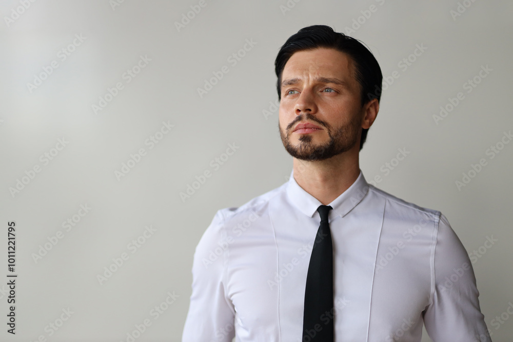 A man wearing a white shirt and black tie is looking at the camera. He is deep in thought A man wearing a white shirt and black tie is looking at the camera. He is deep in thought