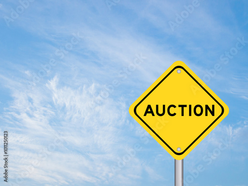 Yellow transportation sign with word auction on blue color sky background